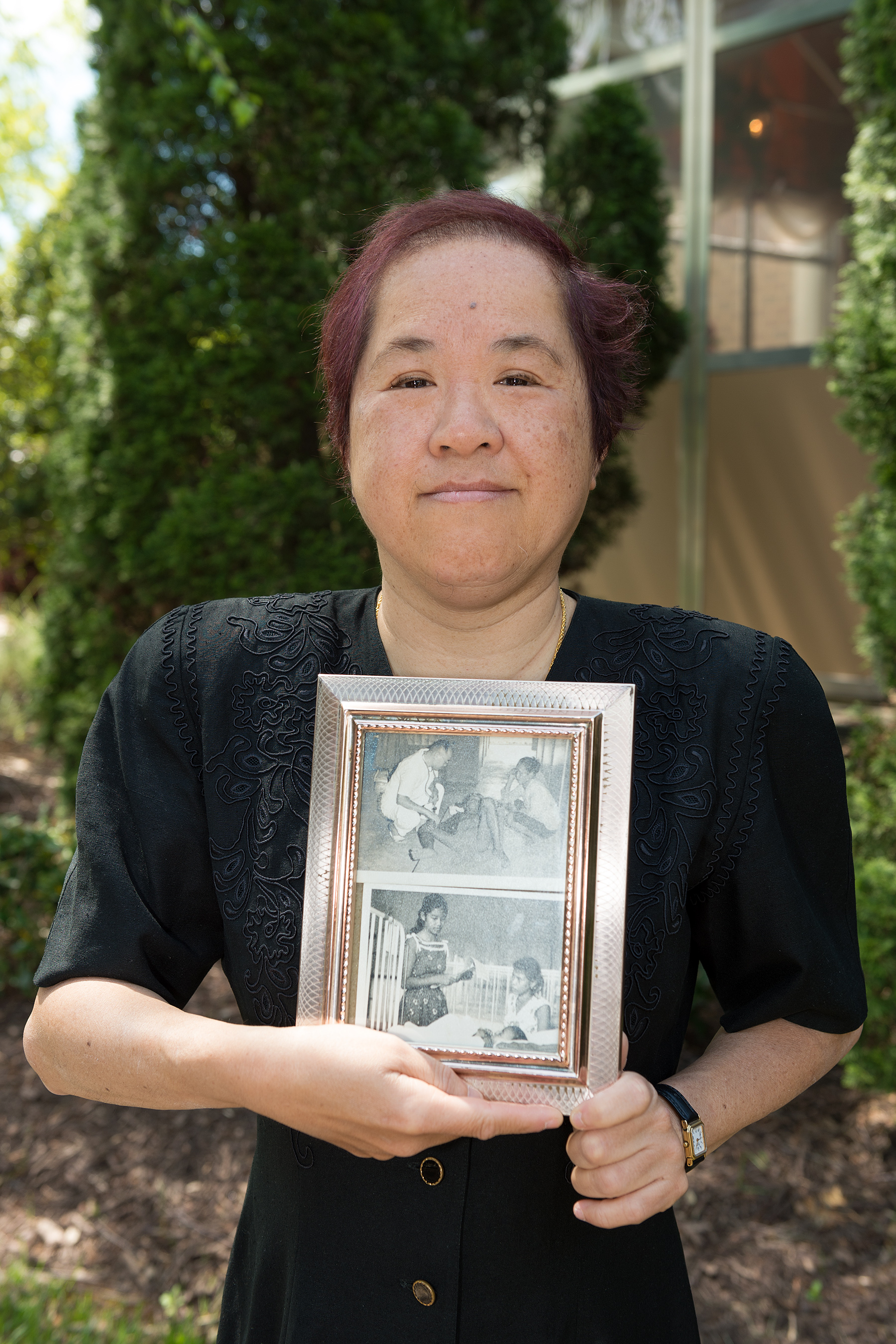 Mary Ding holds pictures of her father and mother, Lillian Chan Ding, M’53, whose careers included practicing in Hong Kong as well as Borneo, where they worked with Aborigines. 